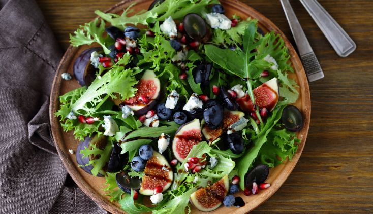 A salad with mixed greens, blueberries and figs.